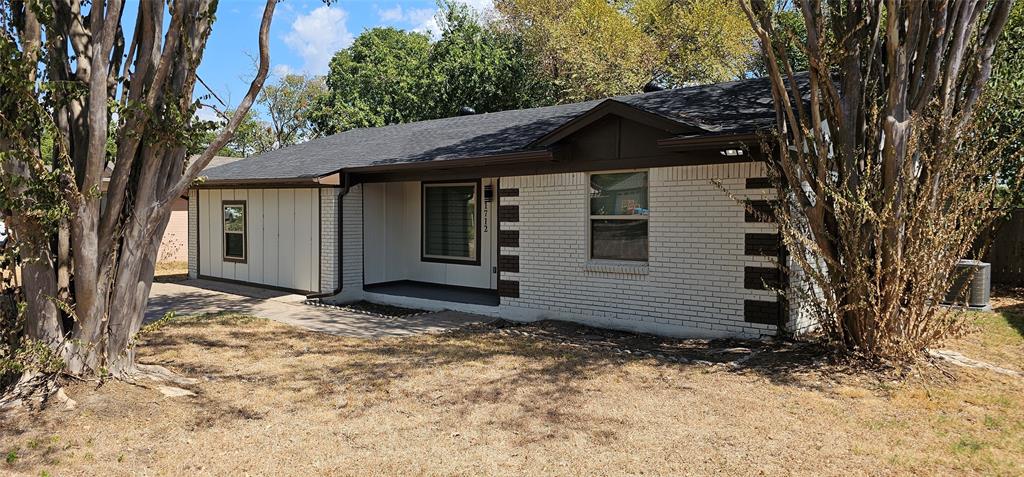 Single-story structure with a covered entry, white painted brick exterior, and dark trim details Single-story structure with a covered entry, white painted brick exterior, and dark trim details