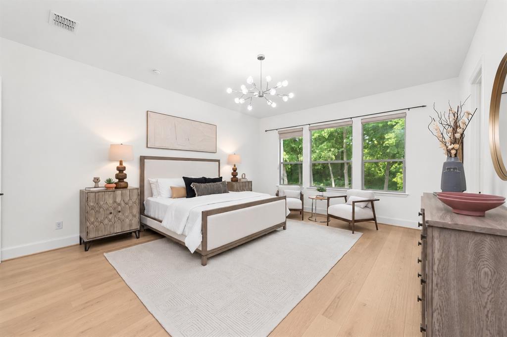 Light wood-finish flooring, white walls, and a contemporary chandelier