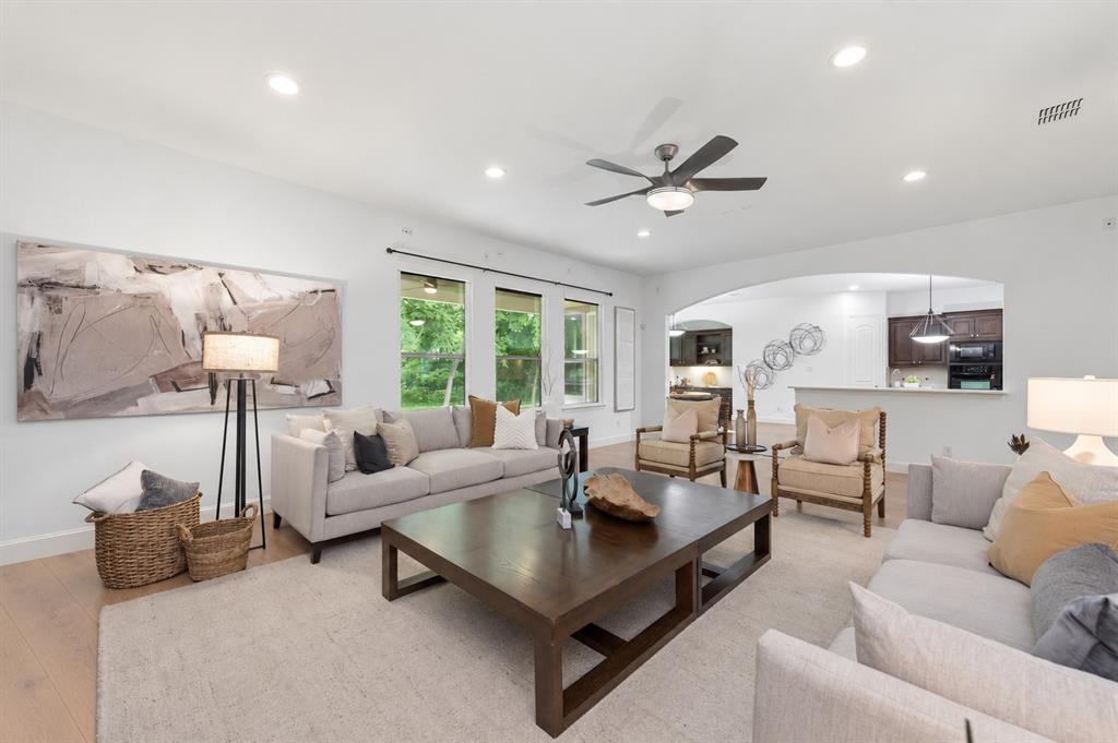 Spacious living area featuring wood-finish flooring, recessed lighting, and a ceiling fan
