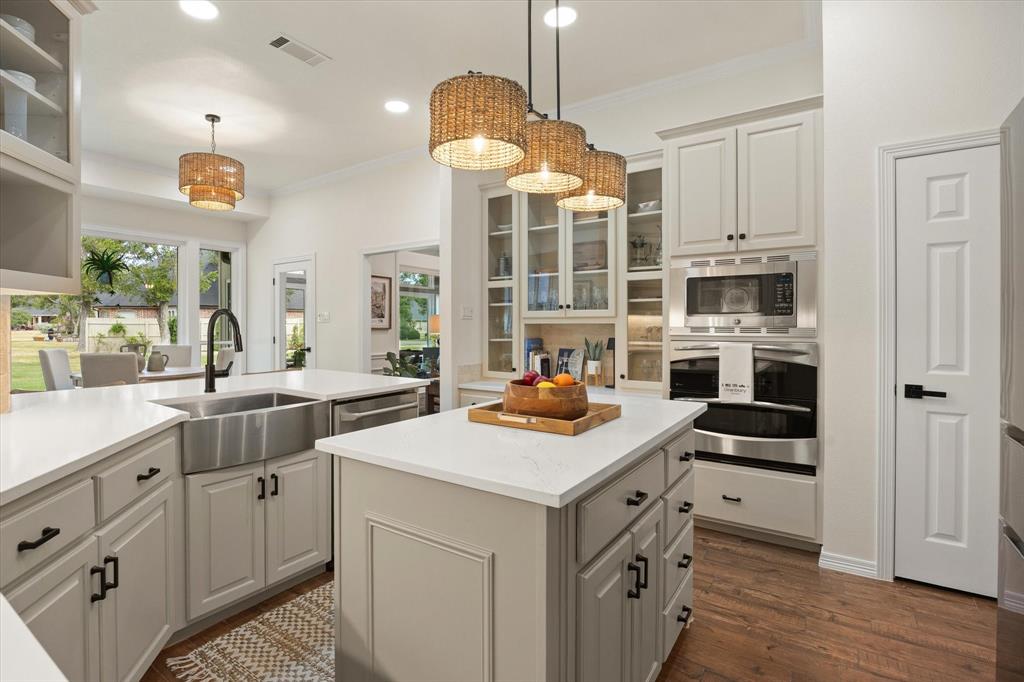 Stainless Steel Farmhouse Sink with Designer Faucet, Double Oven, Microwave, Custom Cabinets with Built-In Menu Planning Desk Complete this Chef's Kitchen