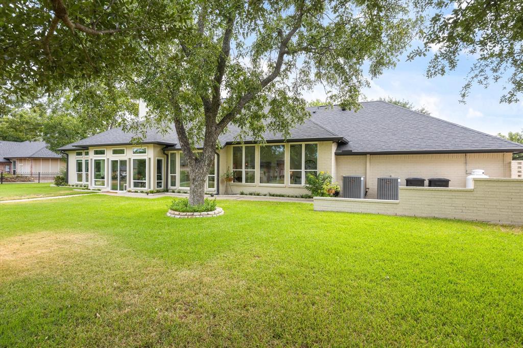 Wall of Windows Across Rear of Home Overlook Golf Course and Mature Trees