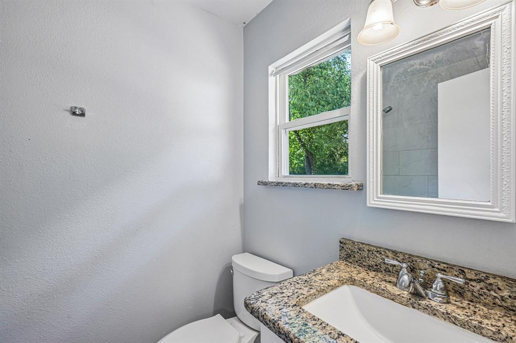 Granite countertop with integral sink, chrome faucet, and decorative framed mirror