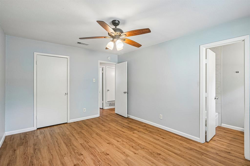 Wood-finish flooring, light blue wall paint, white trim, and a ceiling fan with integrated lighting