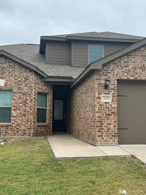 Brick facade with coordinating siding accents, an attached garage, and a covered entry Brick facade with coordinating siding accents, an attached garage, and a covered entry