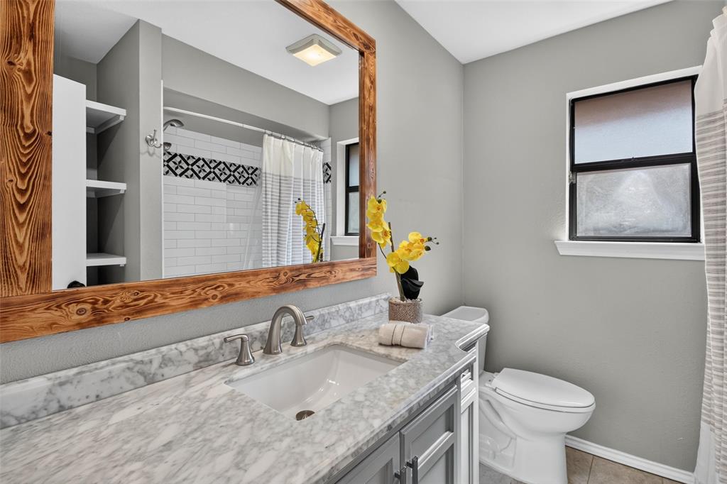 Vanity with a light-colored countertop, undermount sink, and brushed nickel faucet