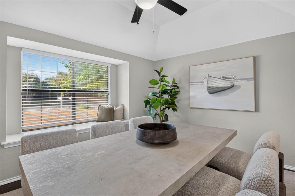 Vaulted ceiling, ceiling fan, expansive bay window, window seat, and neutral wall finishes