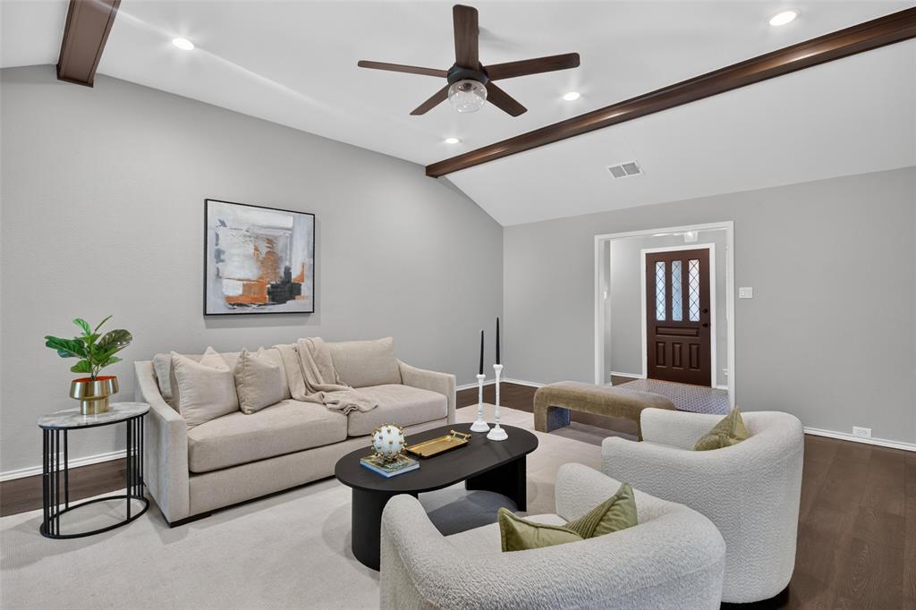 Vaulted ceiling with exposed wood beams, recessed lighting, and a ceiling fan