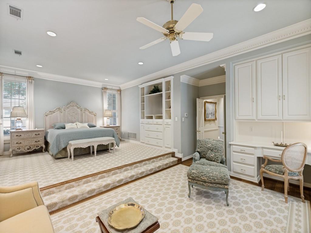 Raised sleeping area with recessed lighting, crown molding, built-in cabinetry, ceiling fan, and dedicated desk space