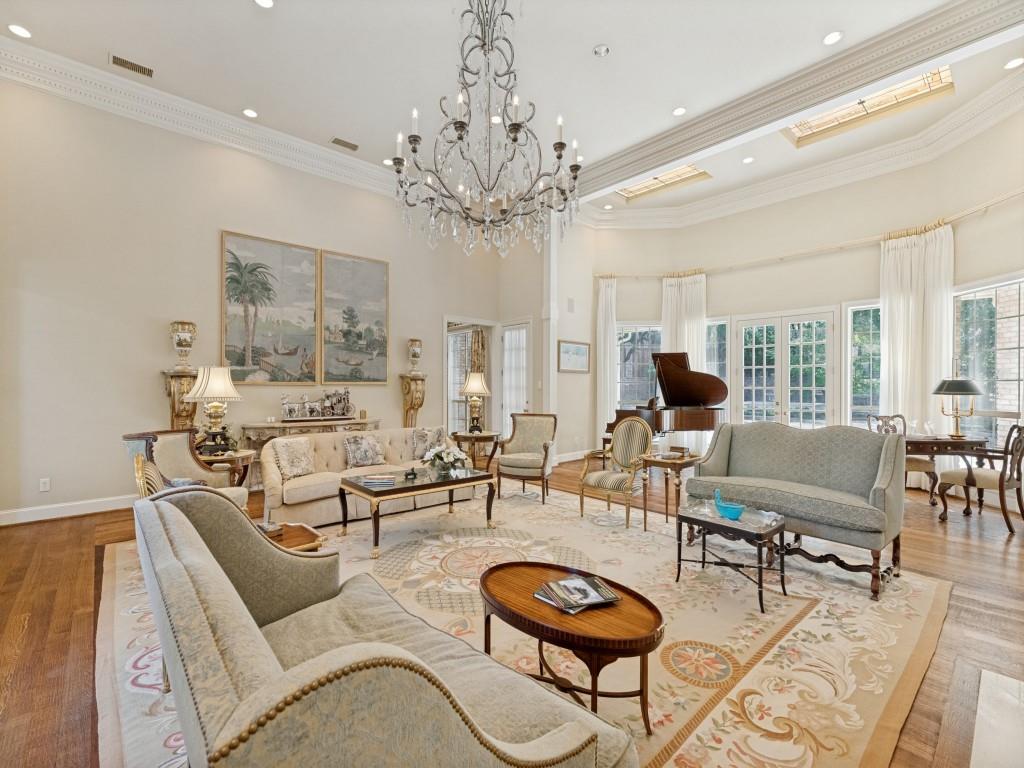 Hardwood flooring, high ceilings with crown molding, recessed lighting, chandelier lighting, and multiple French doors
