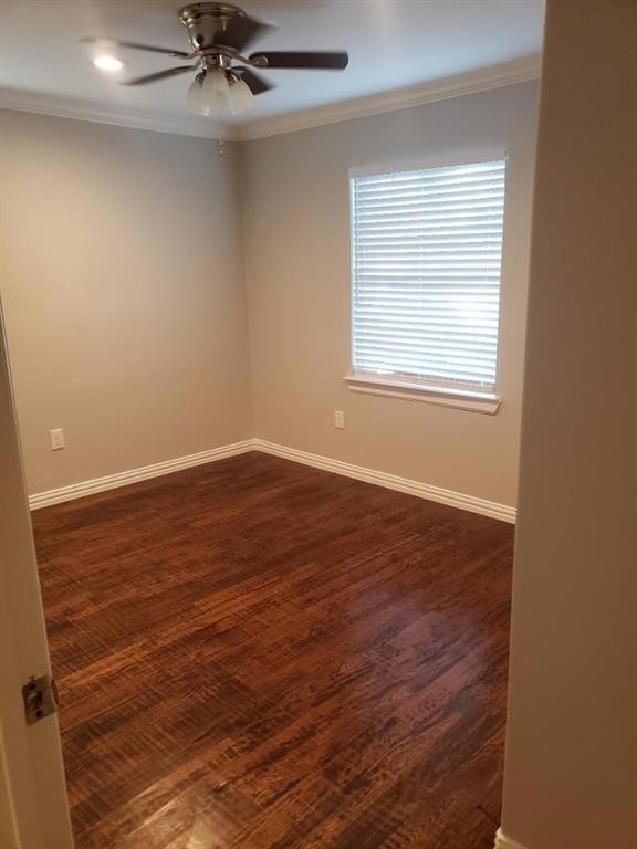 Wood-finish flooring, crown molding, ceiling fan with integrated lighting, and a window with blinds