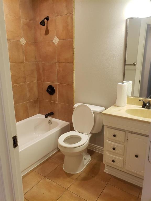 Bathroom featuring a tile-surround shower with dark bronze fixtures, a white bathtub, a toilet, and a vanity with an integrated sink