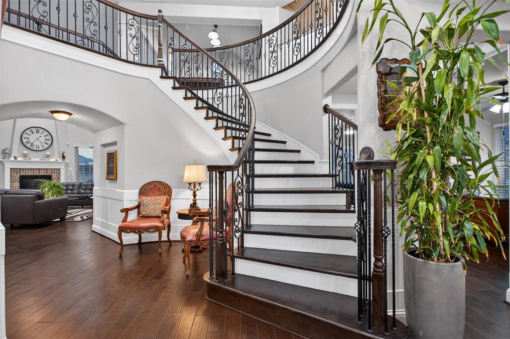 Curved staircase with wrought iron balusters and dark wood-finish treads Curved staircase with wrought iron balusters and dark wood-finish treads