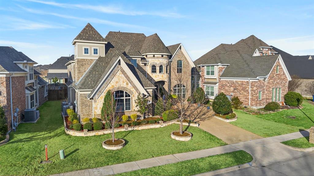 Multi-level residence featuring brick and stone exterior, gabled rooflines, an arched window, and a prominent turret