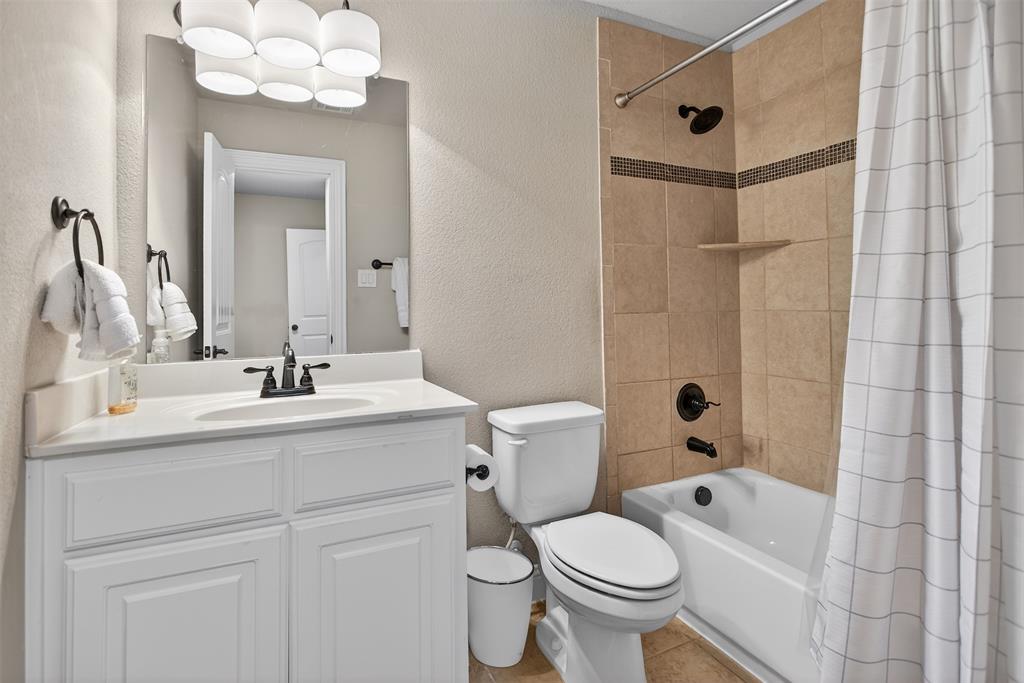White vanity with cabinet storage, integrated sink, and dark bronze faucet