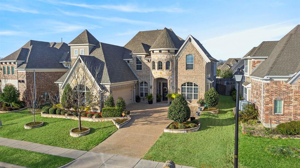 Brick and stone exterior with a turret, arched entry, and pitched rooflines