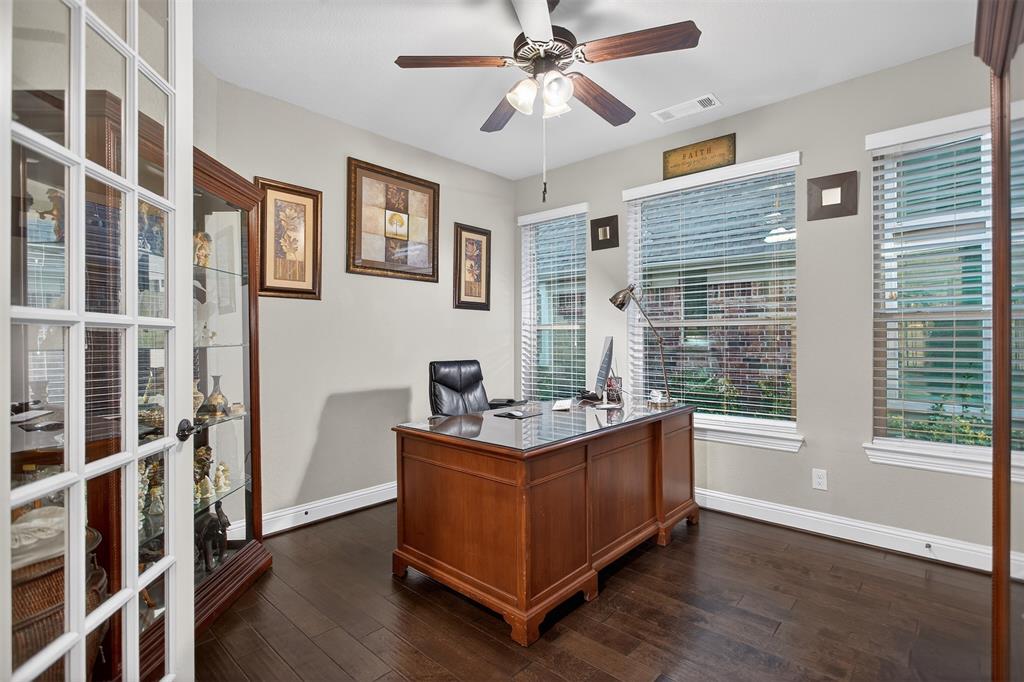 Wood-finish flooring, multiple windows, ceiling fan, and French doors Wood-finish flooring, multiple windows, ceiling fan, and French doors
