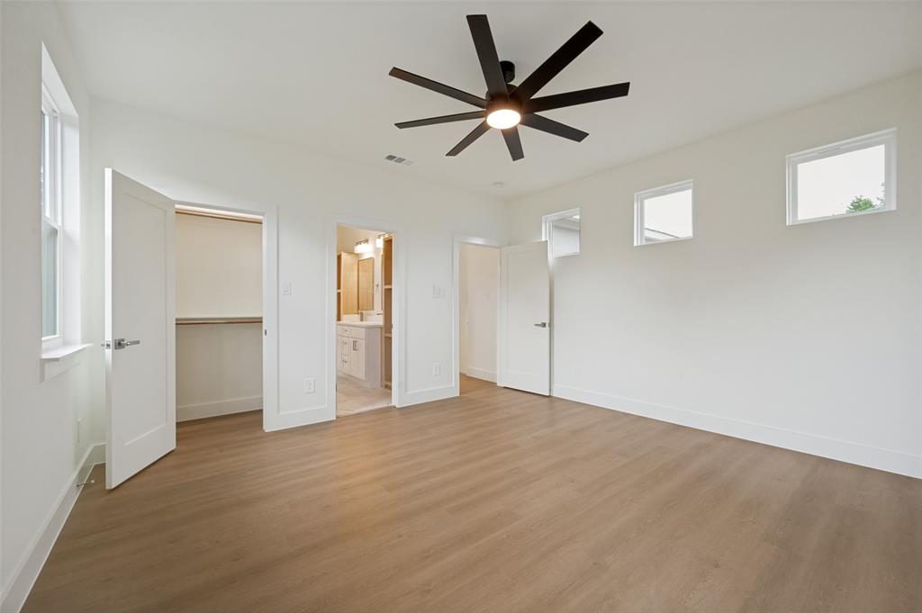Spacious room featuring wood-finish flooring, a modern ceiling fan, recessed lighting, and multiple windows