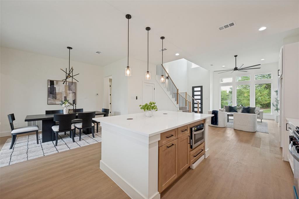 Spacious open-concept living area with wood-finish flooring