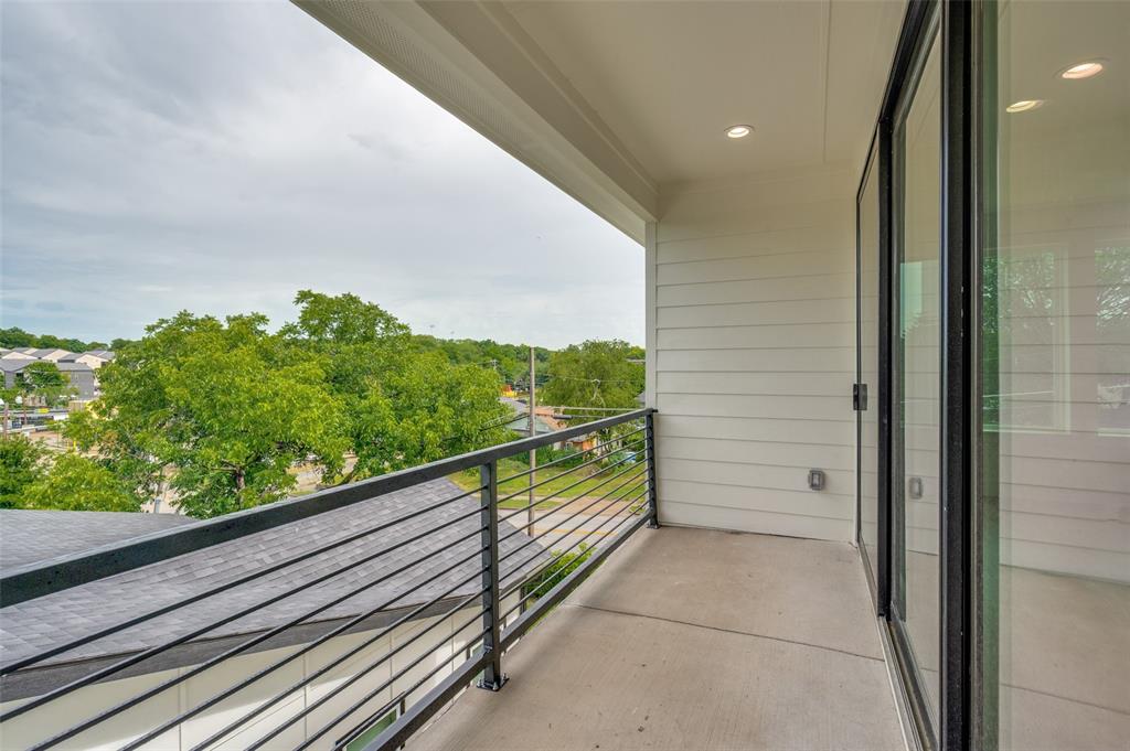 Private balcony featuring a concrete floor, black metal railing, recessed lighting, and expansive sliding glass doors