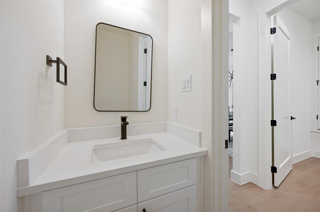 White vanity with shaker-style cabinetry, an integrated sink, and a matte black single-handle faucet