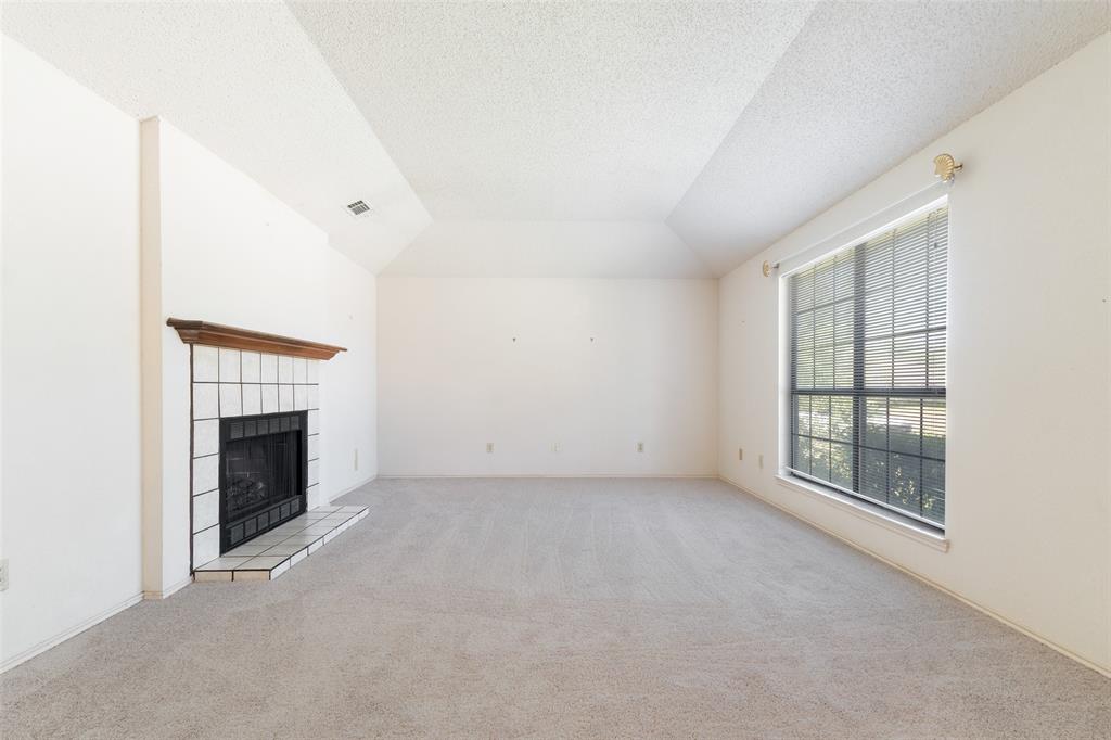 A very spacious living room with a wood burning fireplace.