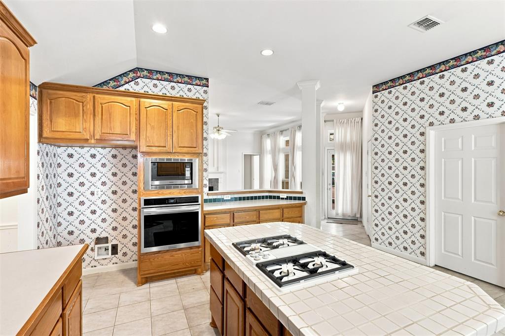 Kitchen featuring a built-in oven, built-in microwave, and wood cabinetry.