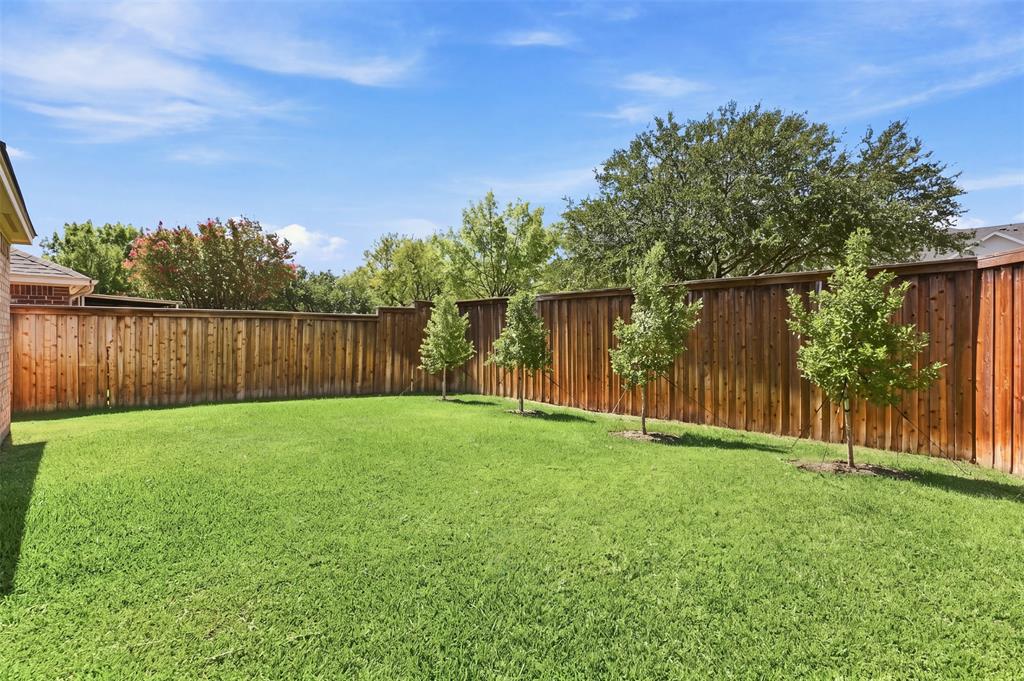 Additional backyard features include full-height privacy fencing, and view of mature trees.