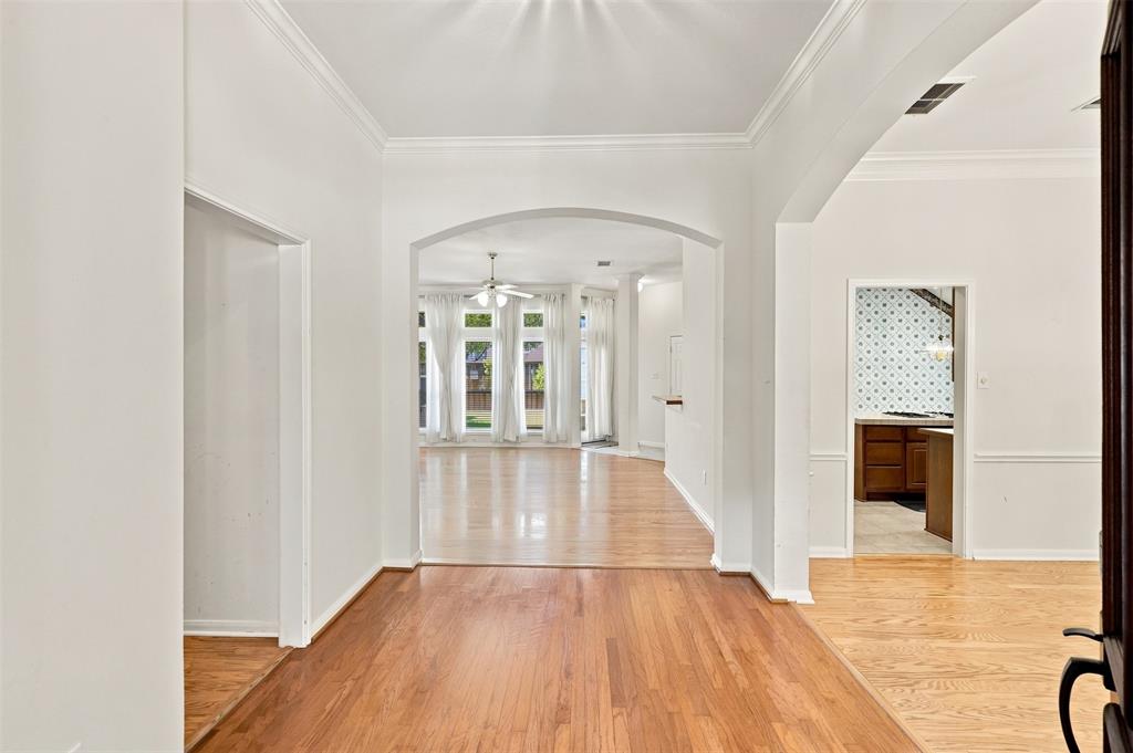 Hardwood floors throughout the entry with arched openings to living room and dining room.