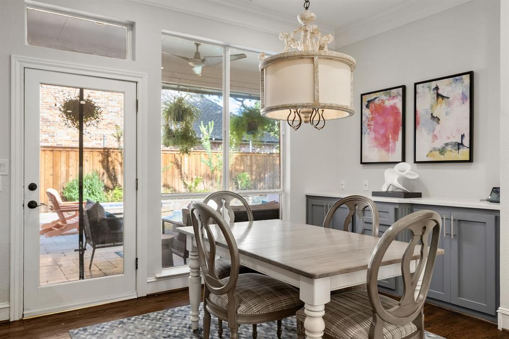 Pristine breakfast room with custom cabinetry, decorative lighting & views of the backyard oasis.