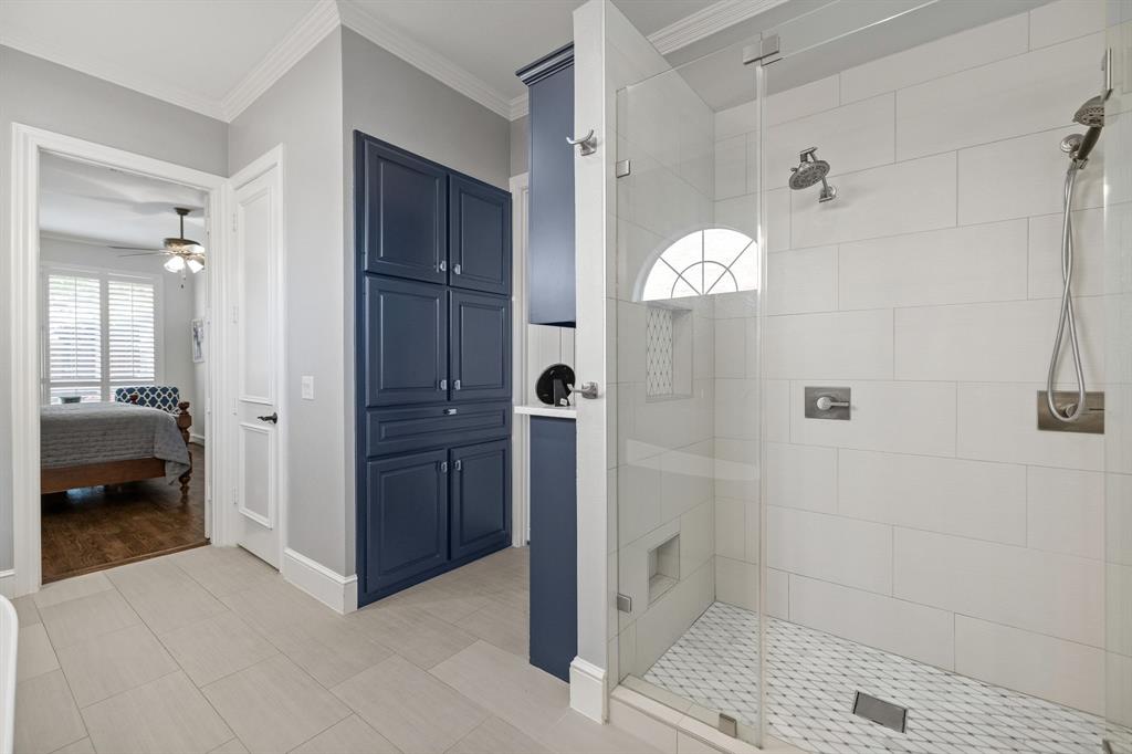 Additional storage in custom cabinetry leading to an extended walk-in closet with built-ins.