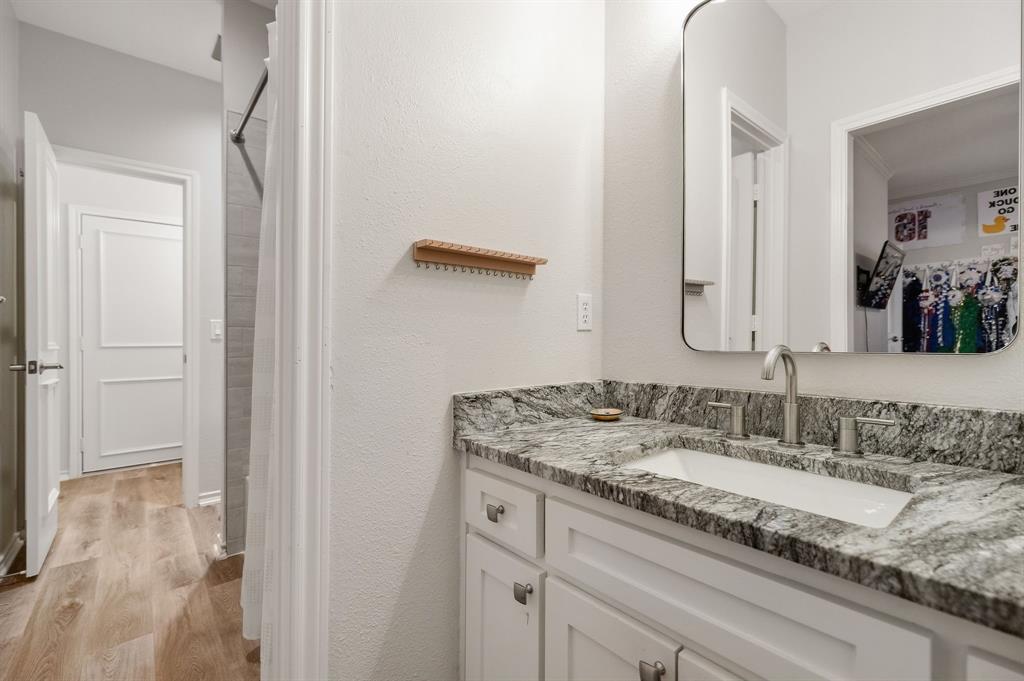 Jack & Jill bathroom with updated cabinetry, granite counters, flooring & shower tile.