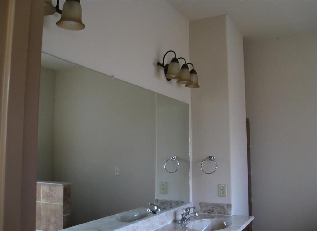 Dual vanity with integrated sinks, polished chrome faucets, and stone countertop Dual vanity with integrated sinks, polished chrome faucets, and stone countertop