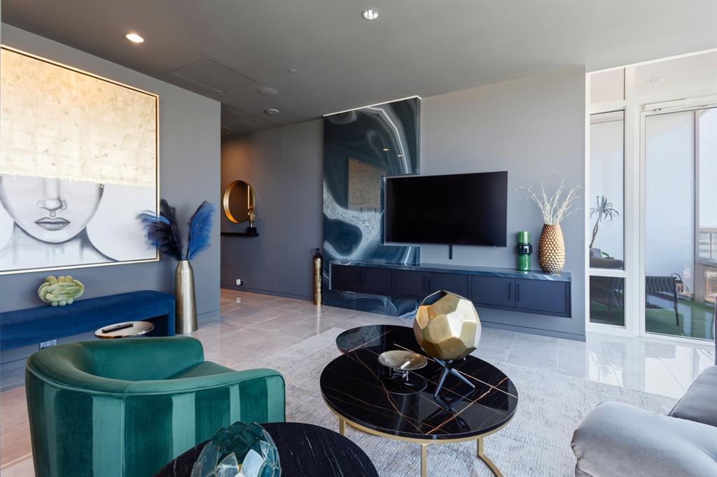 Recessed ceiling lighting, large format tile flooring, a built-in media console, and a wall of windows provide natural illumination Recessed ceiling lighting, large format tile flooring, a built-in media console, and a wall of windows provide natural illumination