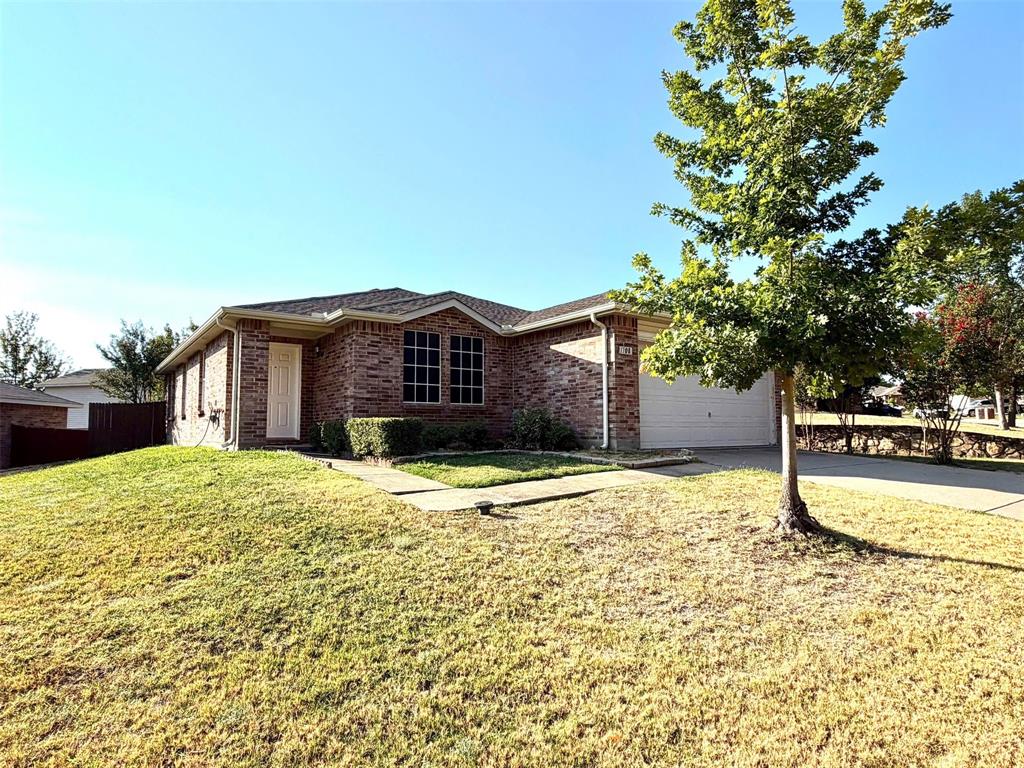 Brick exterior, attached garage, sloped front yard, mature tree, concrete driveway