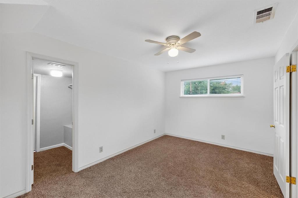 Unfurnished bedroom featuring carpet flooring, a spacious closet, a closet, and ceiling fan