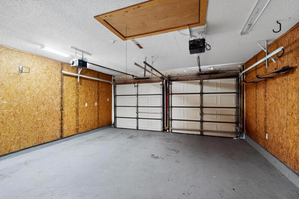 Garage featuring a garage door opener and wooden walls