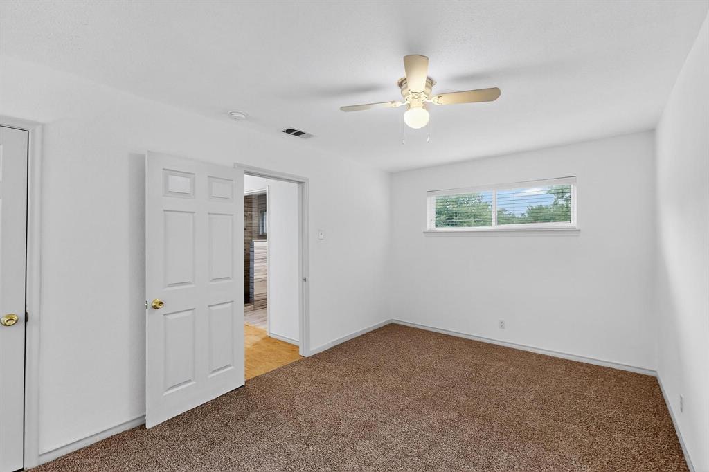 Spare room featuring light colored carpet, ceiling fan, and a smoke detector