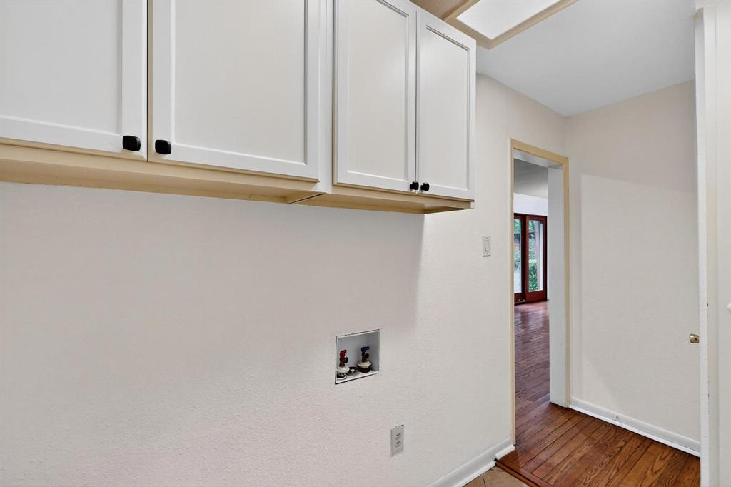 Washroom featuring cabinet space, washer hookup, and wood finished floors