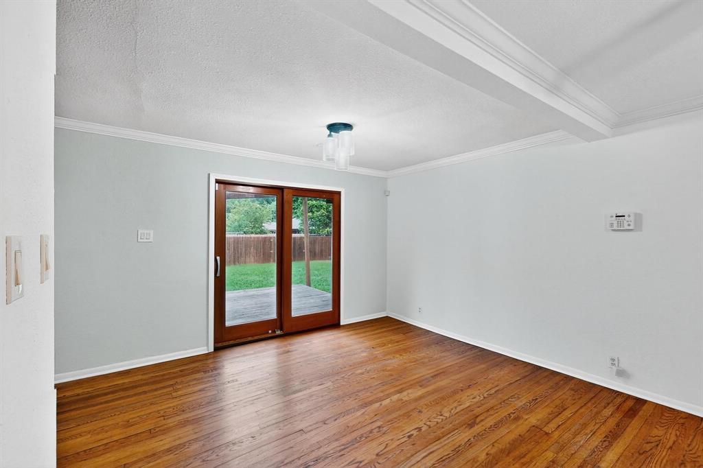 Spare room featuring ornamental molding, hardwood / wood-style flooring, and a textured ceiling Spare room featuring ornamental molding, hardwood / wood-style flooring, and a textured ceiling