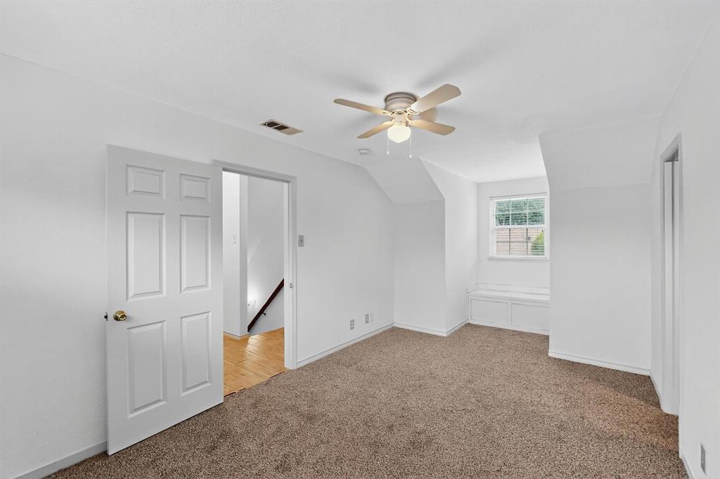 Additional living space featuring light colored carpet, a ceiling fan, and lofted ceiling