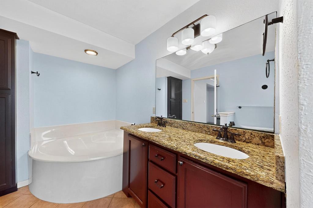 Full bathroom with a bath, double vanity, and tile patterned floors