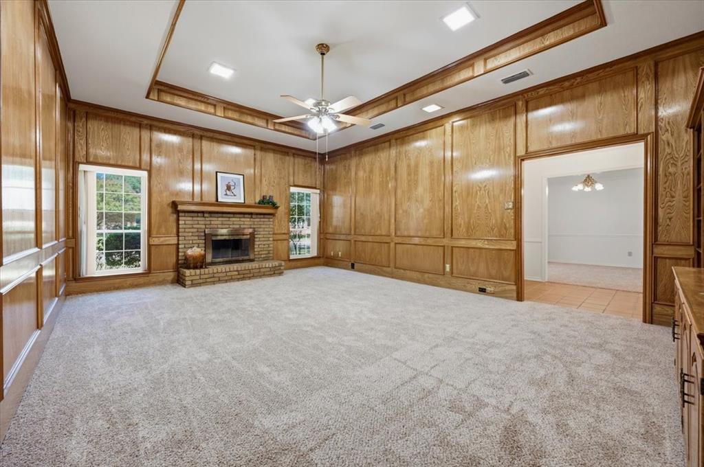 Formal Living room - with lovely custom paneling, fireplace with raised hearth - opposite end of the room features a full wall of custom cabinets and shelving - fresh carpeting and pad 8/2026 no one has lived on this Formal Living room - with lovely custom paneling, fireplace with raised hearth - opposite end of the room features a full wall of custom cabinets and shelving - fresh carpeting and pad 8/2026 no one has lived on this
