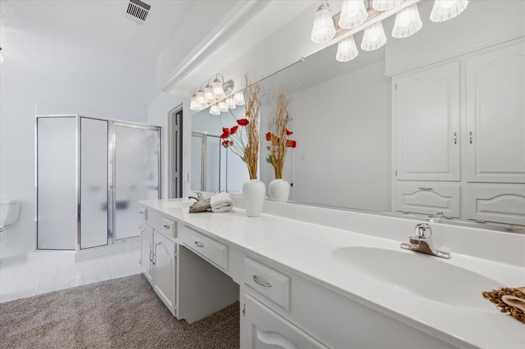 Featuring 2 sinks, walk-in-shower - wall of cabinets for linens and storage - lots of counter space  - view of large walk in shower