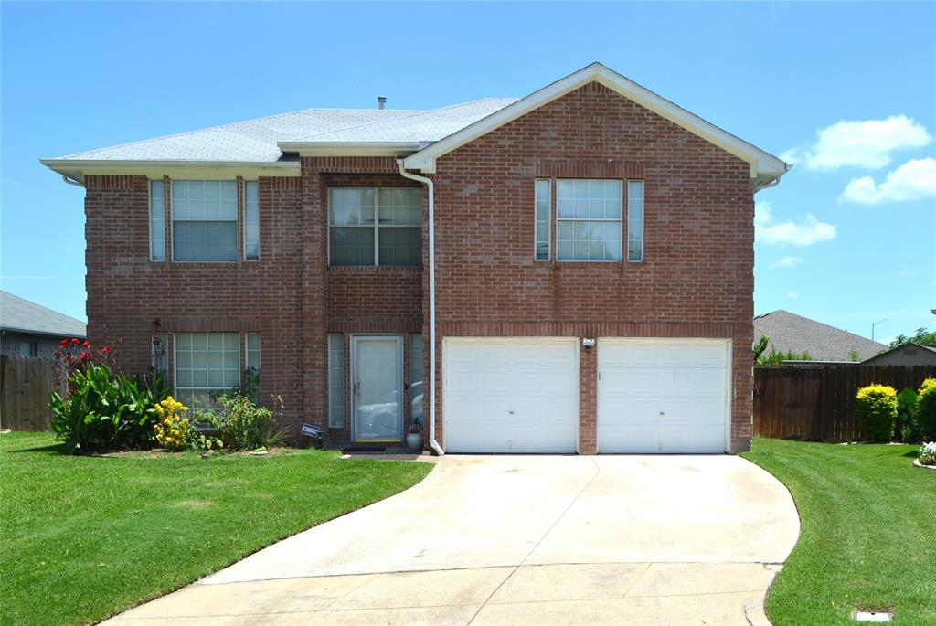 Brick exterior residence featuring a two-car garage, concrete driveway, and front landscaping