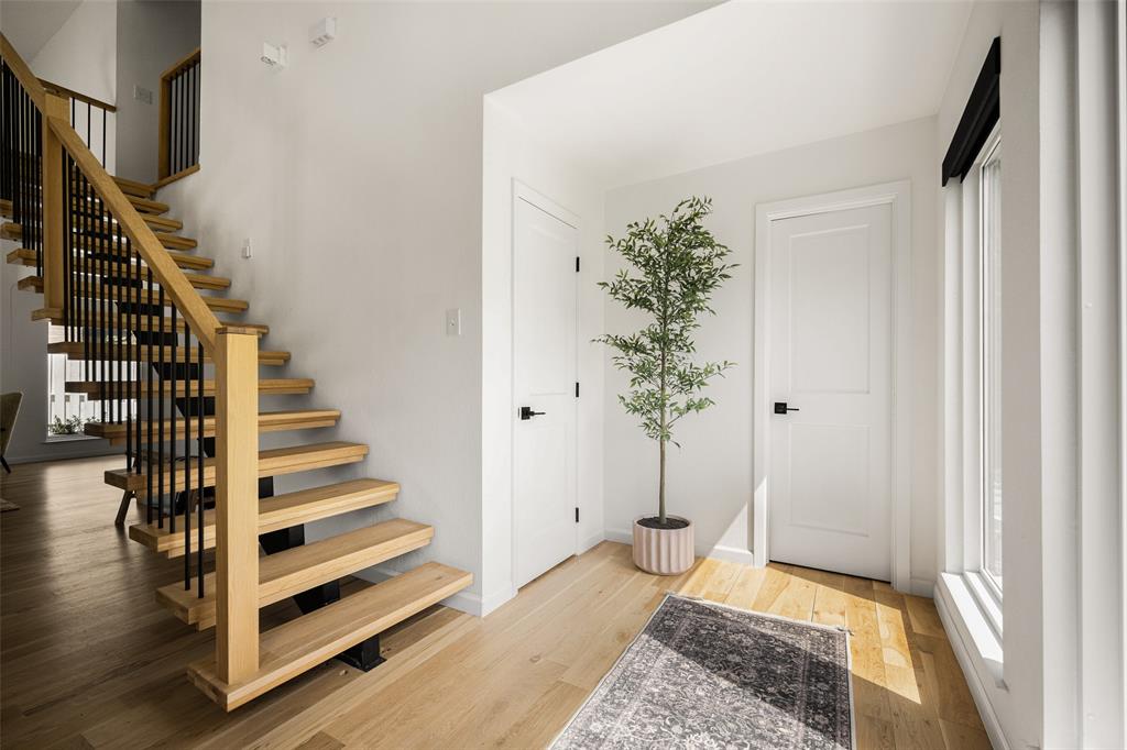 Floating staircase with natural wood treads and black metal balusters