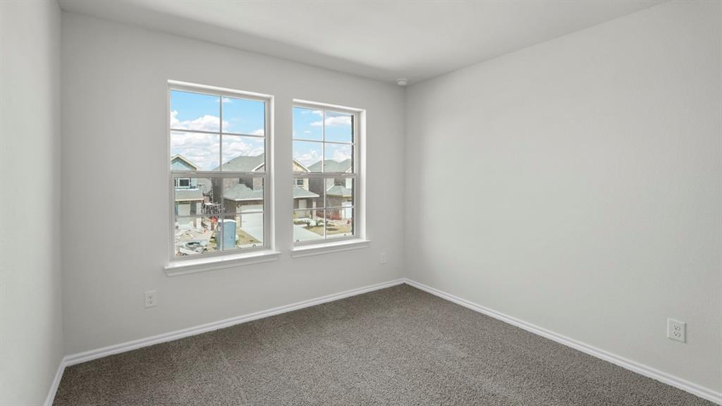 Room featuring two large windows, neutral gray carpeting, and white baseboards