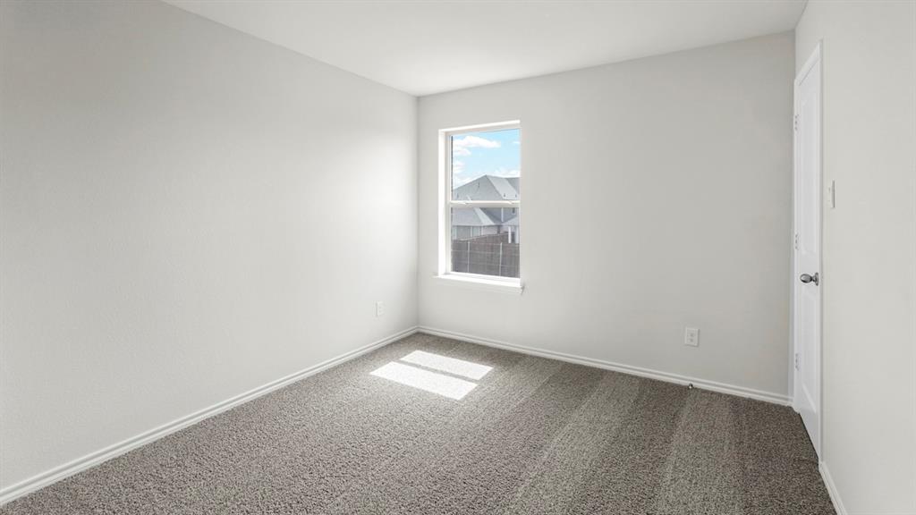 Neutral-toned room featuring a single window, light gray carpeting, and white trim