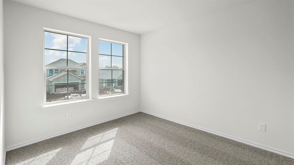 Bright interior space featuring two large windows, white walls, and gray carpet