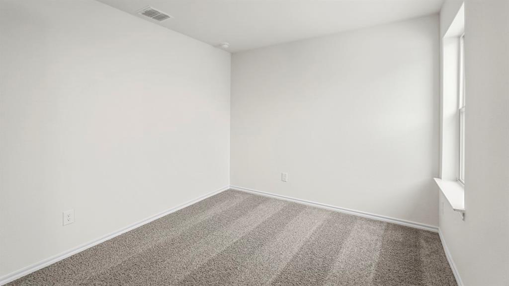 Neutral-toned wall-to-wall carpeting with a window providing natural light