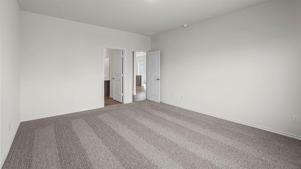 Spacious room featuring light gray carpeting and white painted walls